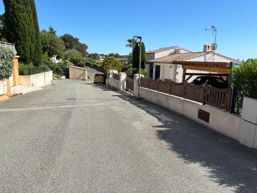 une rue vide avec une clôture et une maison dans l'établissement Studio indépendant cosy, à Fréjus
