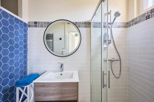 une salle de bain avec un lavabo et une douche avec un miroir dans l'établissement Landemer - A 700 m de la plage, à Barneville-Carteret