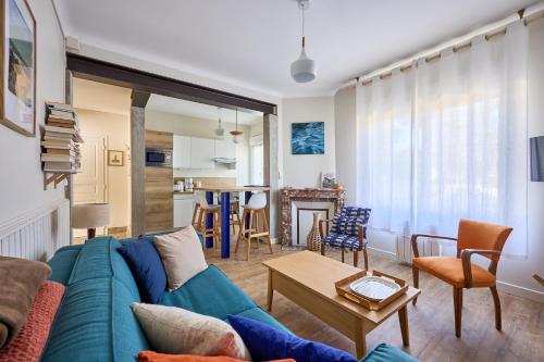 un salon avec un canapé bleu et une table dans l'établissement Landemer - A 700 m de la plage, à Barneville-Carteret