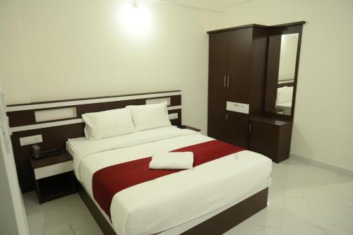 a bedroom with a large bed and a cabinet at CAT'S EYE Hotel in Cochin