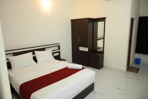 a bedroom with a large bed and a cabinet at CAT'S EYE Hotel in Cochin