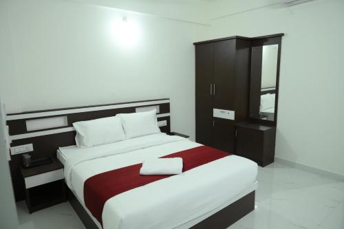 a bedroom with a large bed and a cabinet at CAT'S EYE Hotel in Cochin