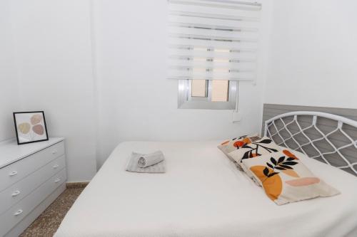 a white bedroom with a white bed and a window at Acogedor Apartamento Valencia 3 dormitorios in Aldaia
