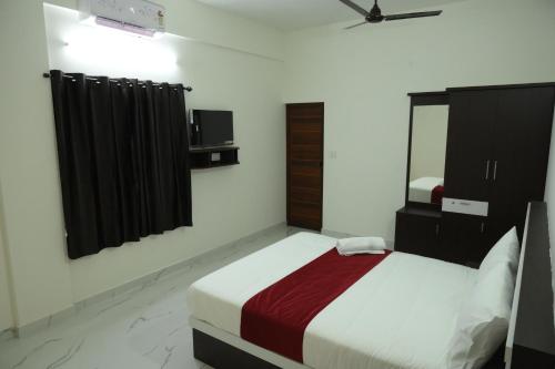 a bedroom with a bed and a mirror at CAT'S EYE Hotel in Cochin