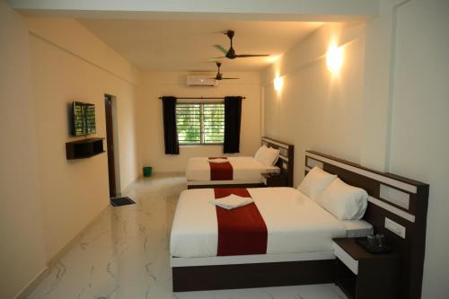 a bedroom with two beds and a window at CAT'S EYE Hotel in Cochin