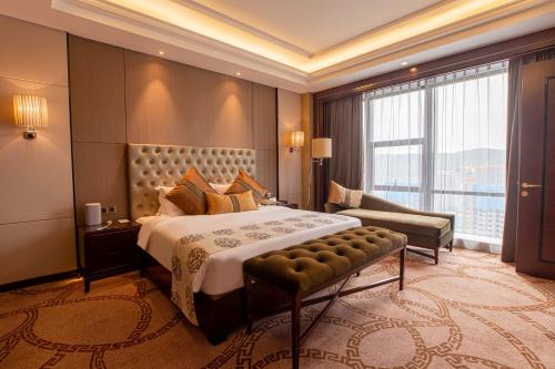 a hotel room with a bed and a large window at Wyndham Grand Plaza Royale Chenzhou in Chenzhou