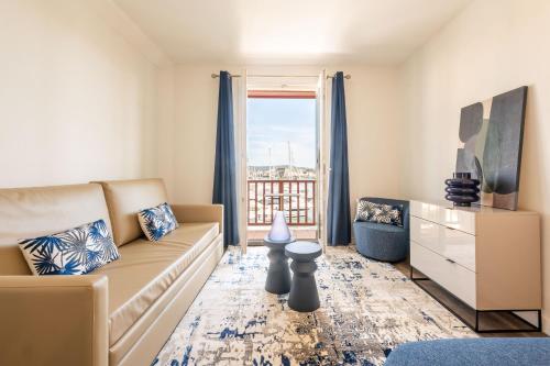 a living room with a couch and a window at Le Suffren Hôtel in Grimaud