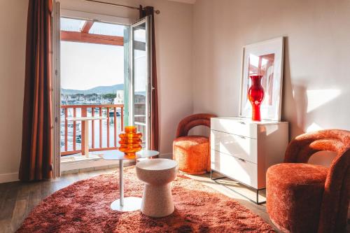 a living room with two chairs and a large window at Le Suffren Hôtel in Grimaud