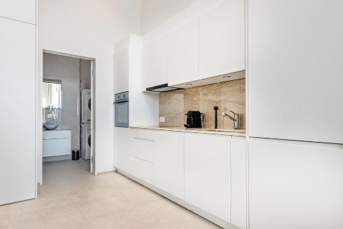 a kitchen with white cabinets and a sink at DESIGN-STUDIO 1 !Gratis Parken, Free Parking! in Kreuzlingen