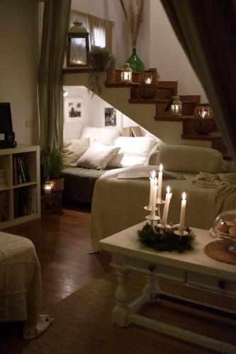 a living room with two beds and candles on a table at B&B La Foglia Verde in Massa