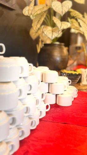 a pile of white cups sitting on a red table at Hotel Seri Malaysia Kepala Batas in Kepala Batas