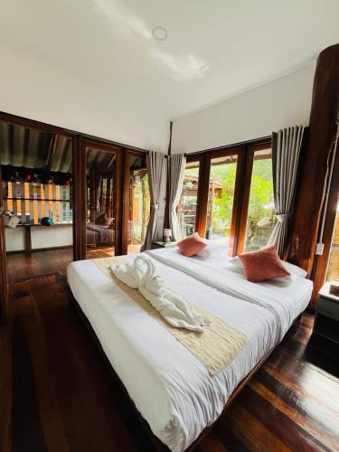 ein großes Schlafzimmer mit zwei Betten und Fenstern in der Unterkunft Ban Tha Ton Do Koh Yao noi in Ko Yao Noi