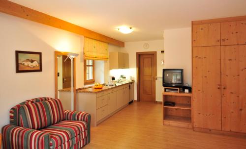 a kitchen with a chair and a tv in it at Seppmair in Lagundo