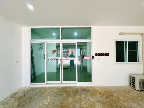 an empty room with glass doors in a building at The Cozy 77 in Bangkok
