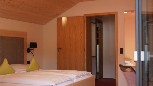 a bedroom with a bed with yellow pillows on it at Hotel Restaurant Frühlingsgarten in Füssen