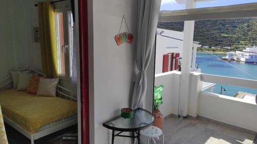 a room with a balcony with a bed and a window at Faros Sea View Studio - Sifnos in Faros