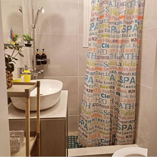 a bathroom with a sink and a shower curtain at Faros Sea View Studio - Sifnos in Faros