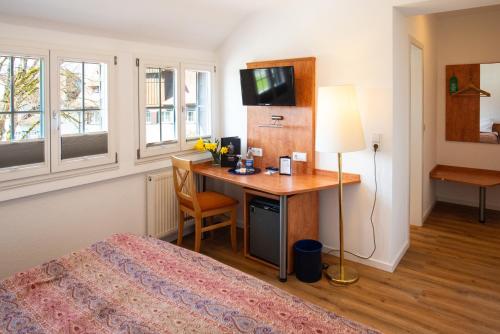 a bedroom with a desk and a bed with a lamp at Insel-Hof Reichenau Hotel-garni in Reichenau