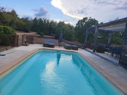 une piscine avec deux chaises et un gazebo dans l'établissement Maison au calme absolue, à Saint-Cézaire-sur-Siagne