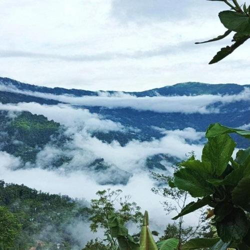 a view of a valley of clouds in the mountains at Khee Homestay in Kurseong