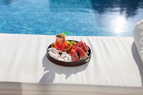 a bowl of fruit on a table next to a pool at Kont Exclusive in Didim
