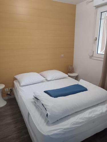 a bed with white sheets and a blue blanket at Les Hauts de Balaruc - CURE THERMALE in Balaruc-les-Bains