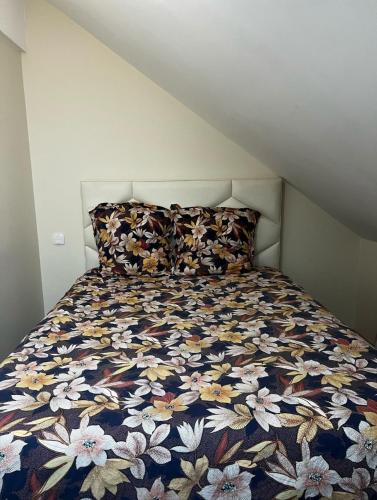 - un lit avec une couette à fleurs dans une chambre dans l'établissement Agréable T2 avec terrasse et parking à La Rochelle - CAR13365HTR, à La Rochelle