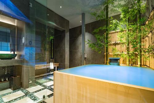 a large blue tub in a bathroom with plants at KONJAKUSO Osaka Bentencho "HIKARIYUYA" Projection M apping SPA in Osaka