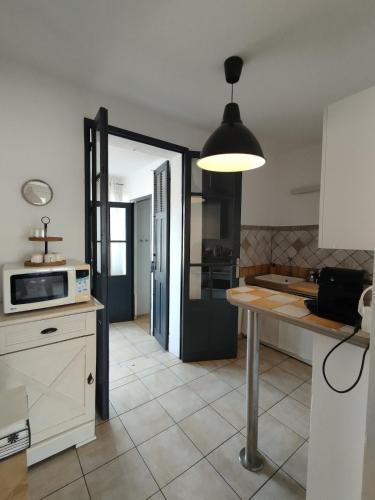 - une cuisine avec une table et un four micro-ondes dans l'établissement 2 chbres idéal pour vacances ou travail, proche centre et port, plage à 2km, wifi, à La Seyne-sur-Mer