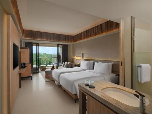 ein Hotelzimmer mit zwei Betten und einem Waschbecken in der Unterkunft Novotel Bali Ubud Resort in Payangan