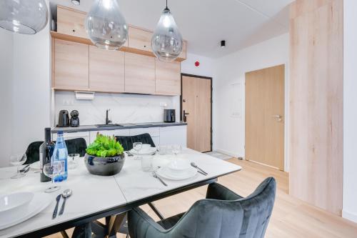 a dining room with a white table and chairs at ReVital Mechelinki by Homeprime Parking Free in Mechelinki