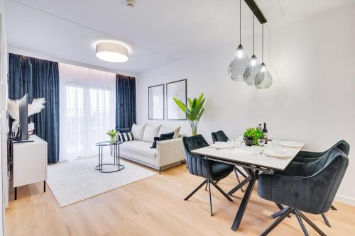 a living room with a table and chairs and a couch at ReVital Mechelinki by Homeprime Parking Free in Mechelinki