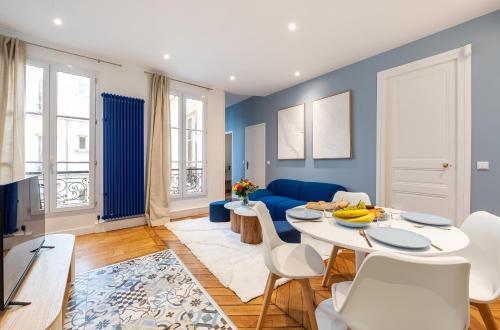 un salon avec une table et un canapé bleu dans l'établissement Mobility lease - Luxembourg Gardens & Montparnasse, à Paris