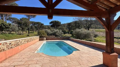 - une piscine dans un patio avec un mur en pierre dans l'établissement Maison calme au cœur des vignes, à Cogolin