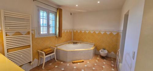 La grande salle de bains est pourvue d'une baignoire et de toilettes. dans l'établissement Maison calme au cœur des vignes, à Cogolin