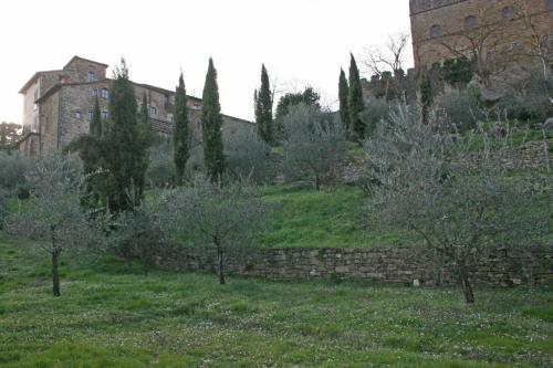 an old stone wall and trees and a building at Albergo San Lorenzo in Poppi