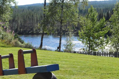 a dog sitting on a bench overlooking a lake at Trysil Hyttegrend in Trysil