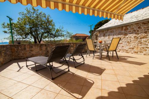 Dubas Studio Apartment في بول: فناء مع كراسي وطاولة وجدار حجري