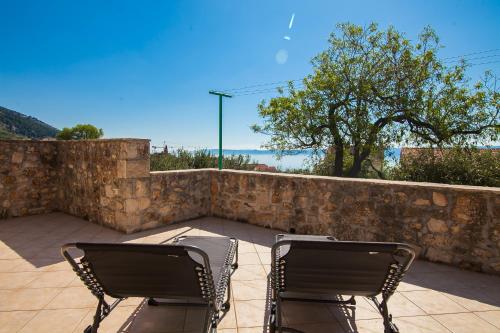 Dubas Studio Apartment في بول: كرسيين جالسين على فناء بحائط حجري