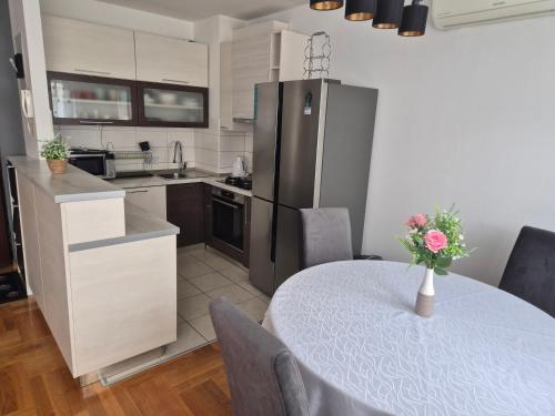 a kitchen with a table with a vase of flowers on it at Apartment ŽNJAN in Split