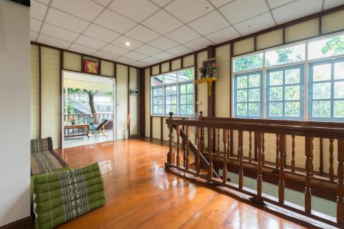 a large room with wooden floors and large windows at NTY Hostel Near Suvarnabhumi Airport in Bangkok
