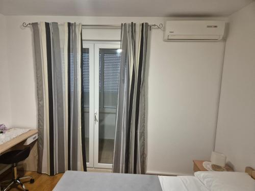 a bedroom with a bed and a window with curtains at Apartment ŽNJAN in Split
