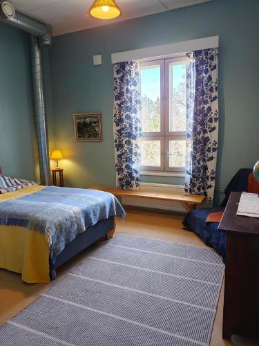 a bedroom with a bed and a window and a rug at Kuohuvirran kartano in Nummistenkylä