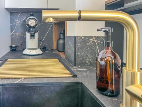 - un évier de cuisine avec une bouteille sur un comptoir dans l'établissement Appartement spacieux et décoré avec goût - quartier Pironnière - 6 personnes, à Les Sables-dʼOlonne