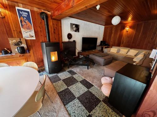 un salon avec un canapé et une cheminée dans l'établissement Chambres d'hôtes de Montagne 