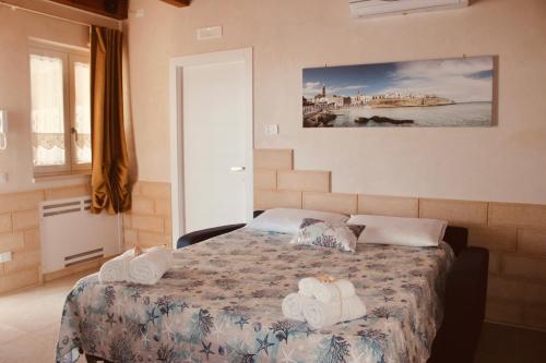 a bedroom with a bed with towels on it at Villa Susca - villa sul mare in Monopoli