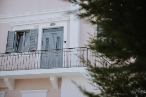 a balcony with a blue door on a building at Leoni's House near the Beach in Kremasti