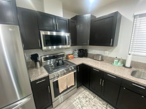 a kitchen with black cabinets and a stove at BonVoyage-Sleep&Sail Overnight Stays-Sleeps 6-8 in Long Beach