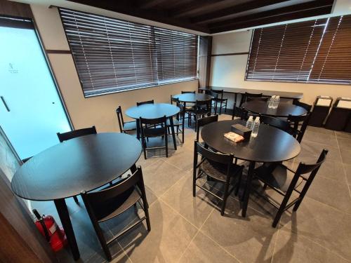 a dining room with tables and chairs and windows at Aank Hotel and Spa Jongno Unni in Seoul