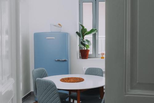 a kitchen with a table and a blue refrigerator at Leoni's House near the Beach in Kremasti